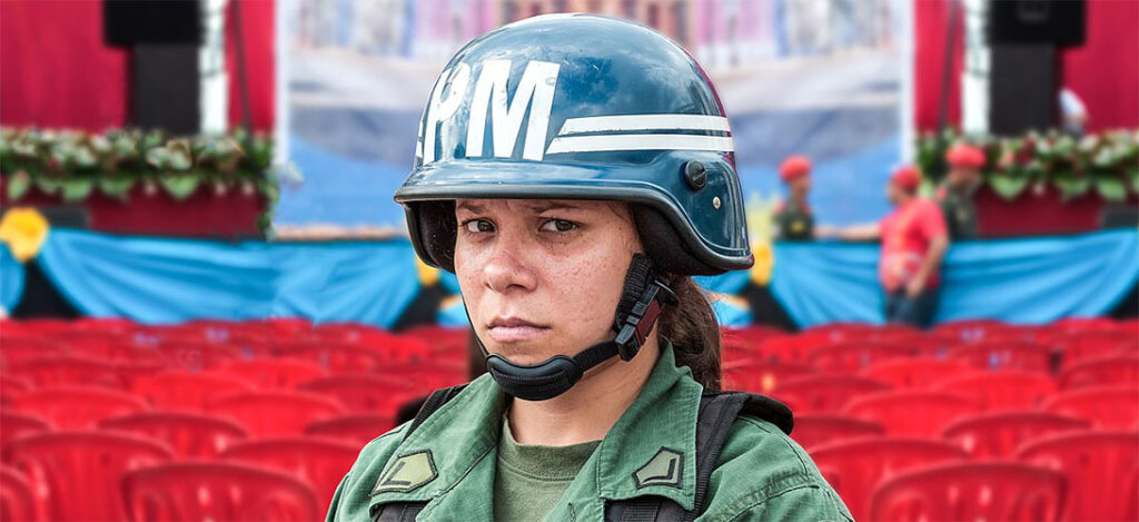 A female soldier looks uneasily into the camera at a political event in Caracas